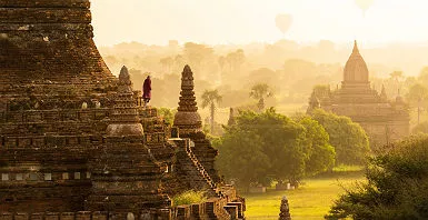 Moine et montgolfières au lever du soleil sur les pagodes de Bagan - Birmanie