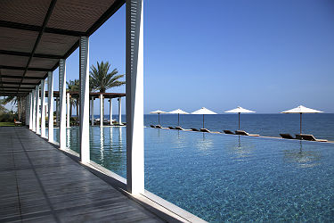 Hôtel Chedi Muscat - Espace piscine avec des chaises longues