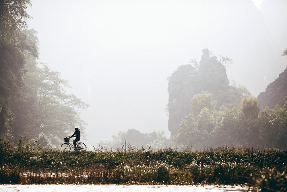 Homme à bicyclette près de la Baie d'Halong au Vietnam