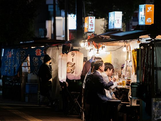 Groupe de personnes assises à un yatai à Fukuoka