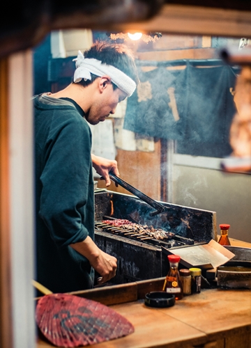 Chef cuisinant des brochettes yakitori